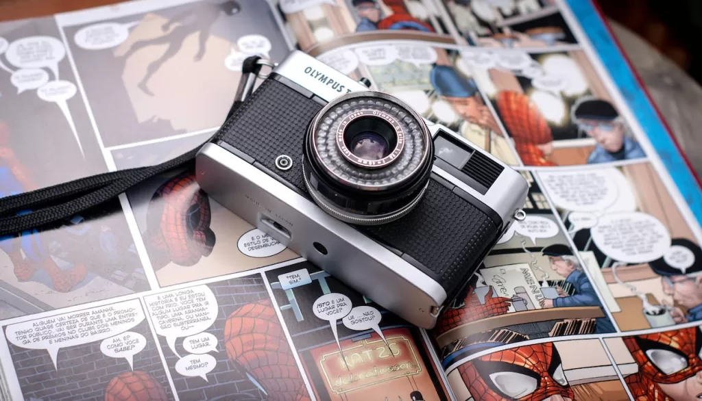 Free From above of opened comics magazine with vintage photo camera placed on top Stock Photo