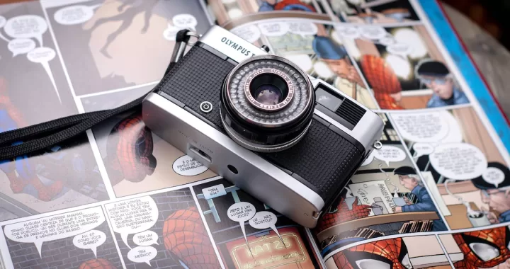 Free From above of opened comics magazine with vintage photo camera placed on top Stock Photo