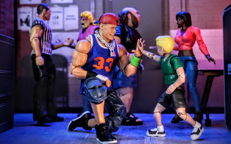 John Cena 2025 Ultimate Fan TakeOver action figure from Mattel, posed with Ultimate Wrestling Fan crowd figures in a detailed toy photography scene.