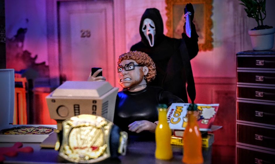 Lloyd Ultimate Wrestling Crowd Fan Figure with NECA Ghostface horror figure in toy photography diorama featuring WWE belt, sodas, and comic book prop.
