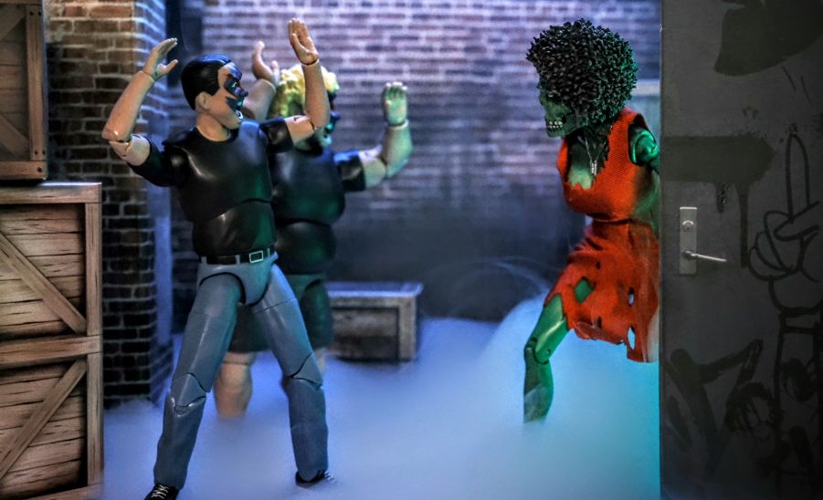 Figures Toy Company Ultimate Wrestling Fans Lance and Shawn encounter the NECA Return of the Living Dead Trash zombie figure emerging from a doorway in a foggy alley
