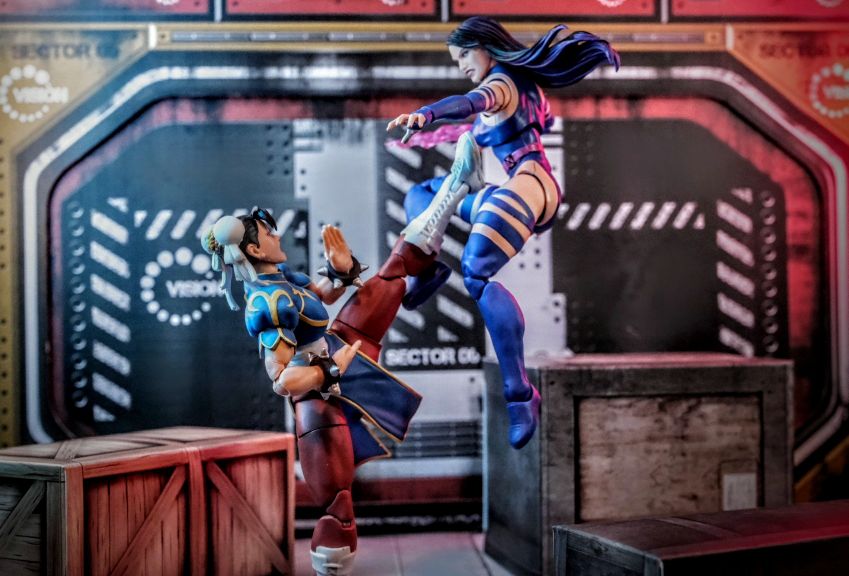 Psylocke vs Chun-Li Marvel Legends Action Figure Diorama Fight Psylocke Marvel Legends figure mid-air kicking Chun-Li action figure in a futuristic diorama battle scene