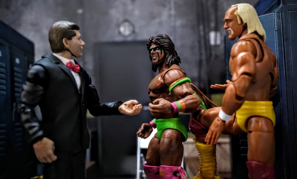 WWE Elite Ultimate Warrior, Vince McMahon, and Hulk Hogan in Mattel Hall of Champions Four-Pack Locker Room Scene Ultimate Warrior WWE Elite figure talking with Build-a-Figure Vince McMahon and WrestleMania III Hulk Hogan inside Extreme-Sets locker room