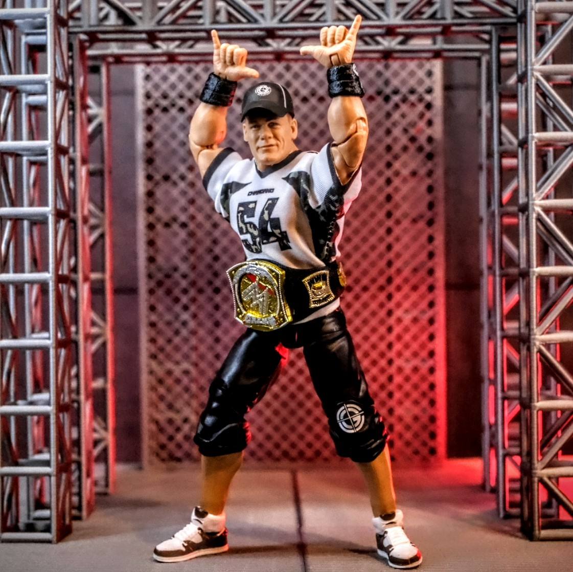 Mattel WWE Hall of Champions John Cena Elite Figure on Custom Entrance Stage Mattel WWE Elite John Cena Hall of Champions figure raising his arms on custom entrance stage with championship title