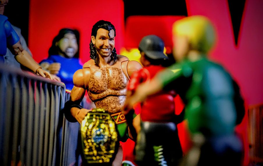 WWE Ultimates Razor Ramon Mattel figure with Intercontinental Championship posing ringside with fans in toy photography