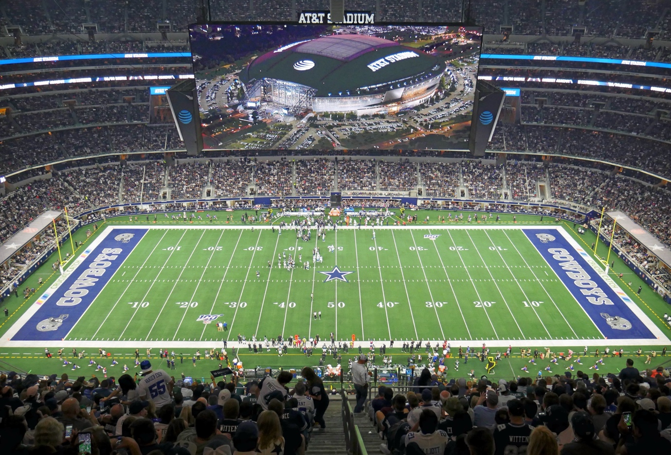 A football stadium with people watching a game with AT&T Stadium in the background AI-generated content may be incorrect.