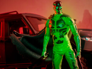 Geiger Elite Edition action figure posed beside a vehicle under red and green lighting